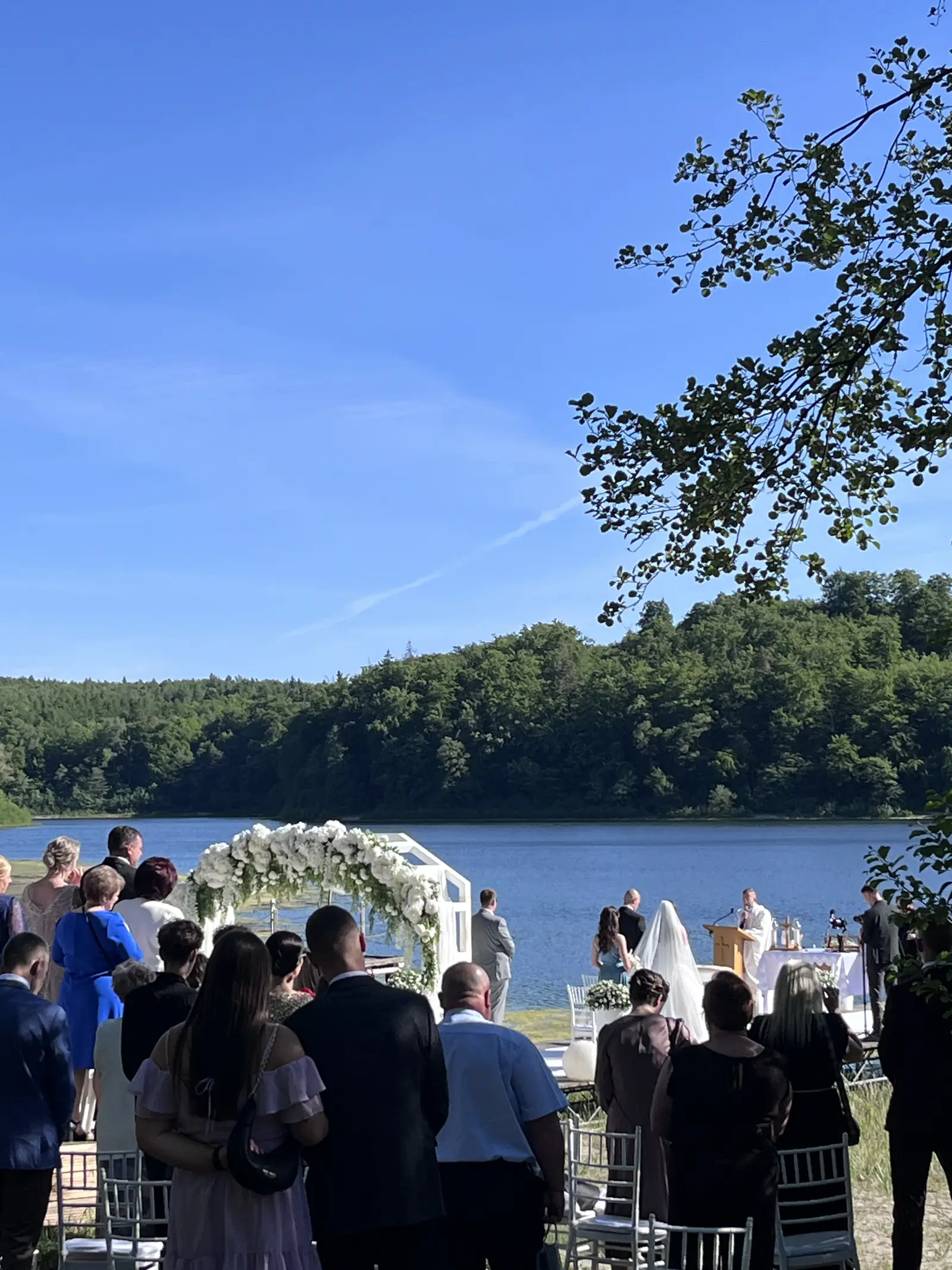Goście podczas ślubu kościelnego nad jeziorem
